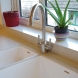 closeup of kitchen taps integrated into acrylic stone worktop